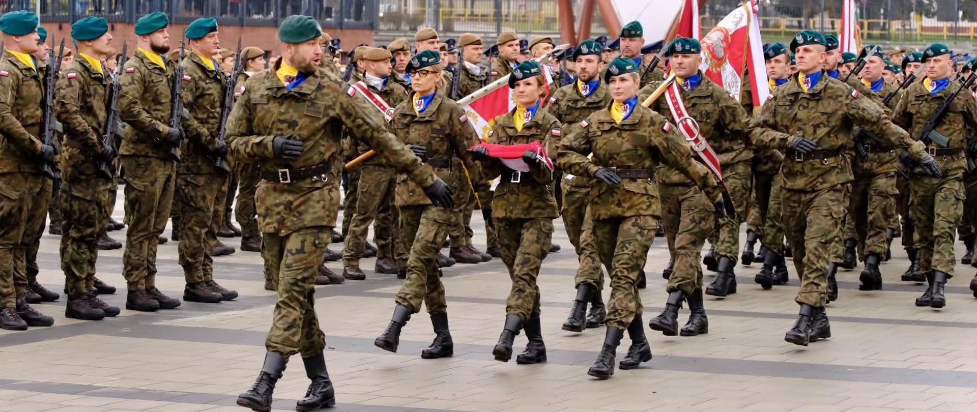 Uroczysta defilada wojskowa podczas Wojewódzkich Obchodów Narodowego Święta Niepodległości na Placu Bohaterów Westerplatte w Bartoszycach. Żołnierze w szyku marszowym oddają hołd bohaterom walk o niepodległość Polski