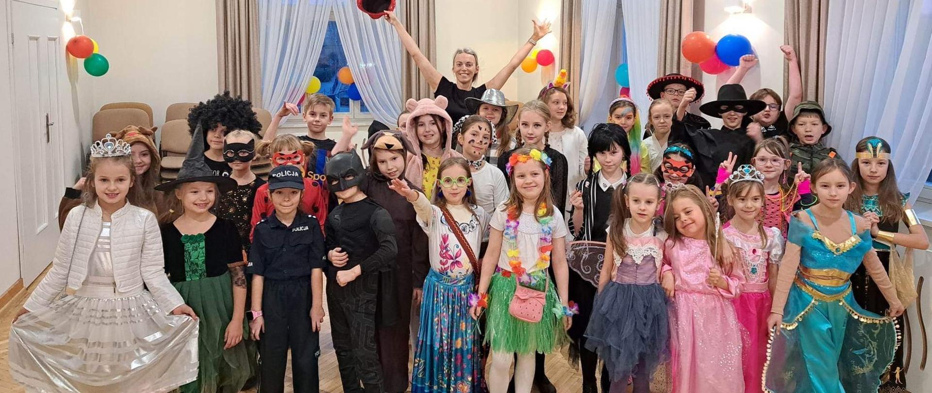 Grafika przedstawia grupę dzieci przebranych w kolorowe stroje karnawałowe.