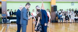Wiceminister Dariusz Piontkowski wręcza nagrodę wyróżniającej się uczennicy