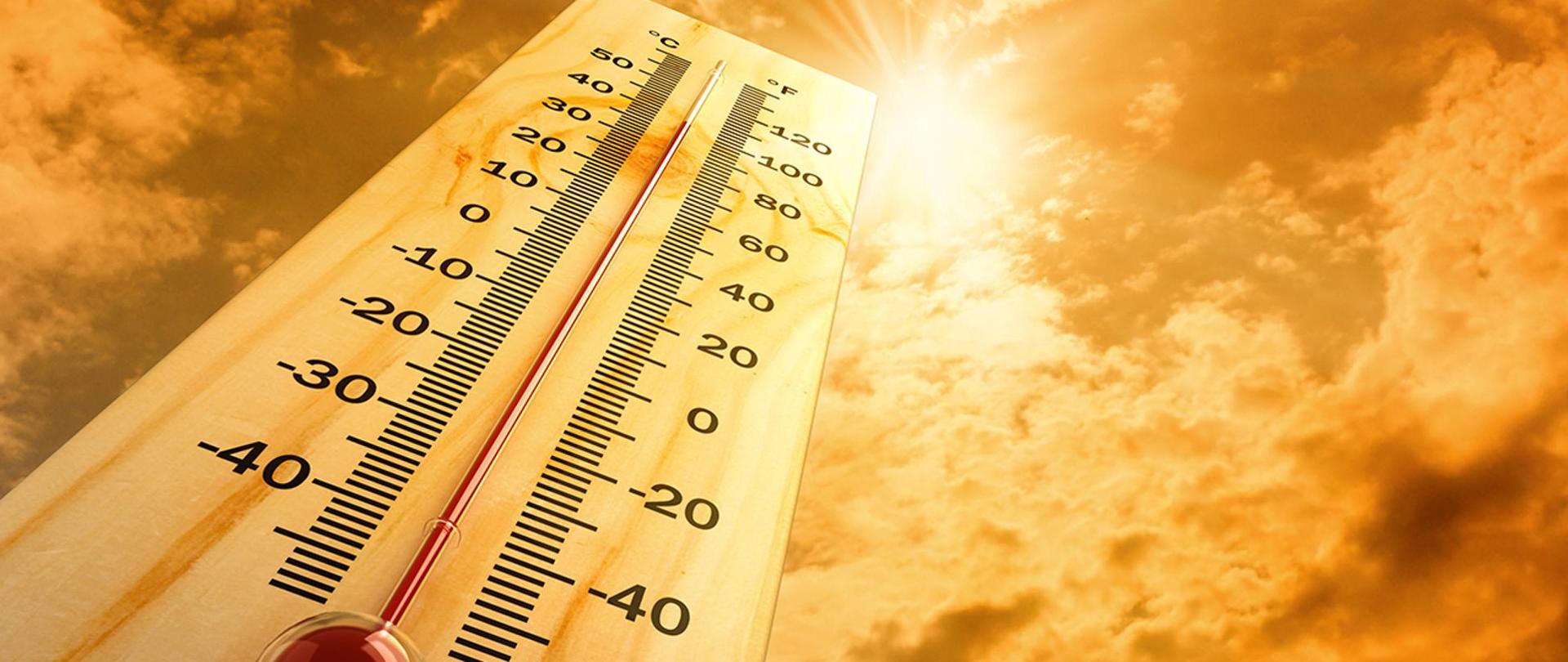 Zdjęcie przedstawia termometr rtęciowy na tle nasłonecznionego nieba ze wskazaniem wysokiej temperatury.