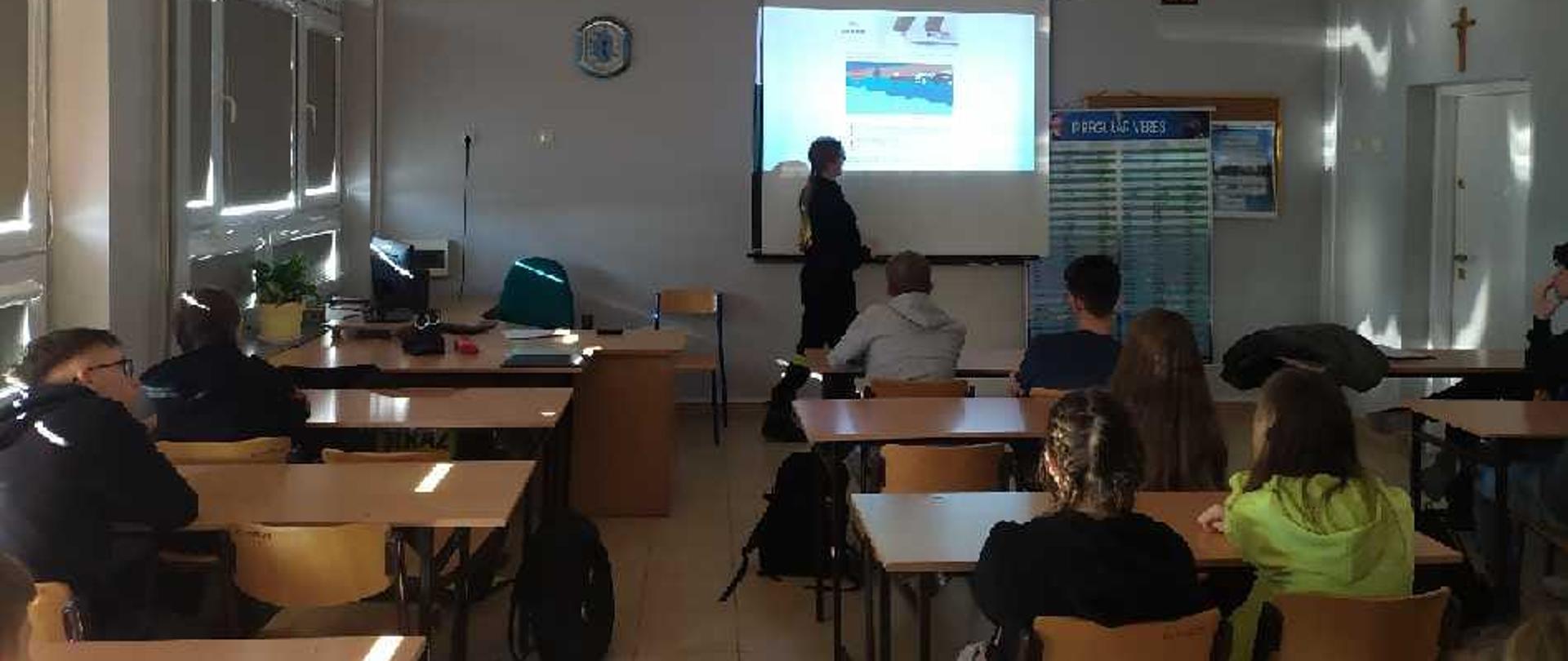 Funkcjonariusz KP PSP Mińsk Mazowiecki opowiada uczniom o zagrożeniach, które mogą ich spotkać podczas zimowego wypoczynku.