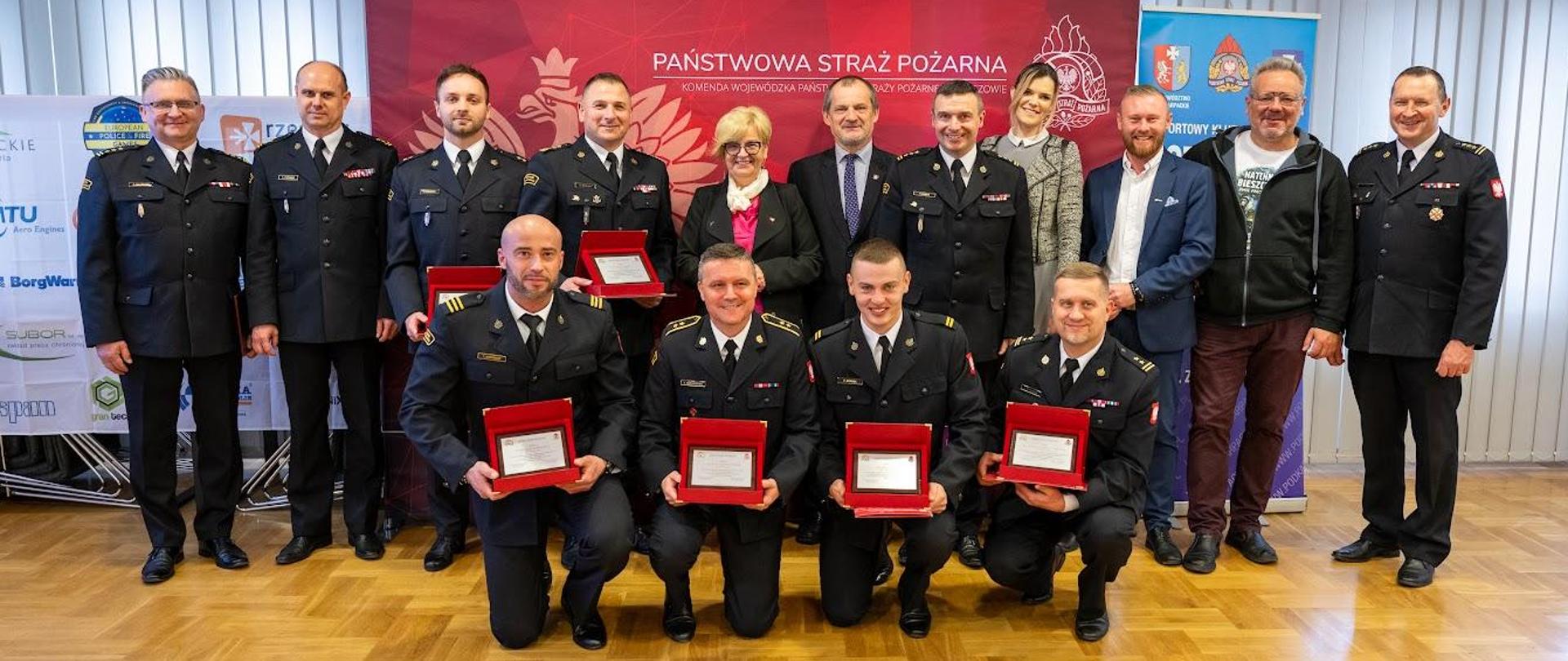 Zdjęcie zrobione w sali konferencyjnej Komendy Wojewódzkiej PSP w Rzeszowie podczas uroczystego spotkania ze strażakami sportowcami. Zdjęcie zbiorowe strażaków i zaproszonych gości.