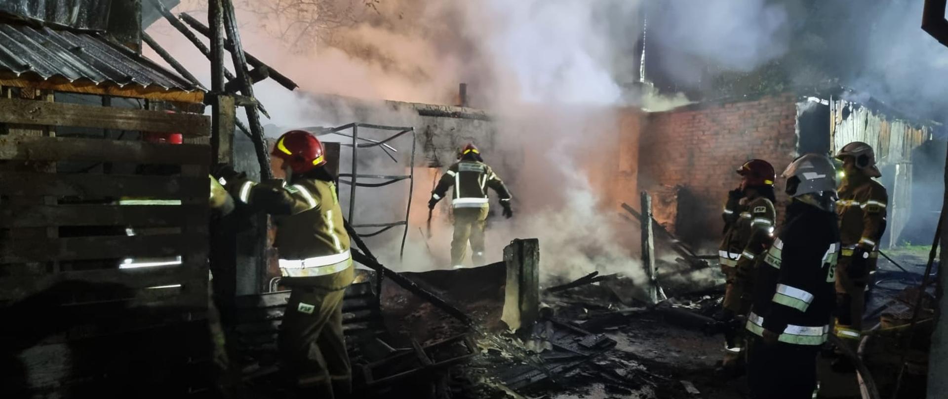 Końcowy etap gaszenia pożaru budynku gospodarczego. Trwa dogaszanie budynku.