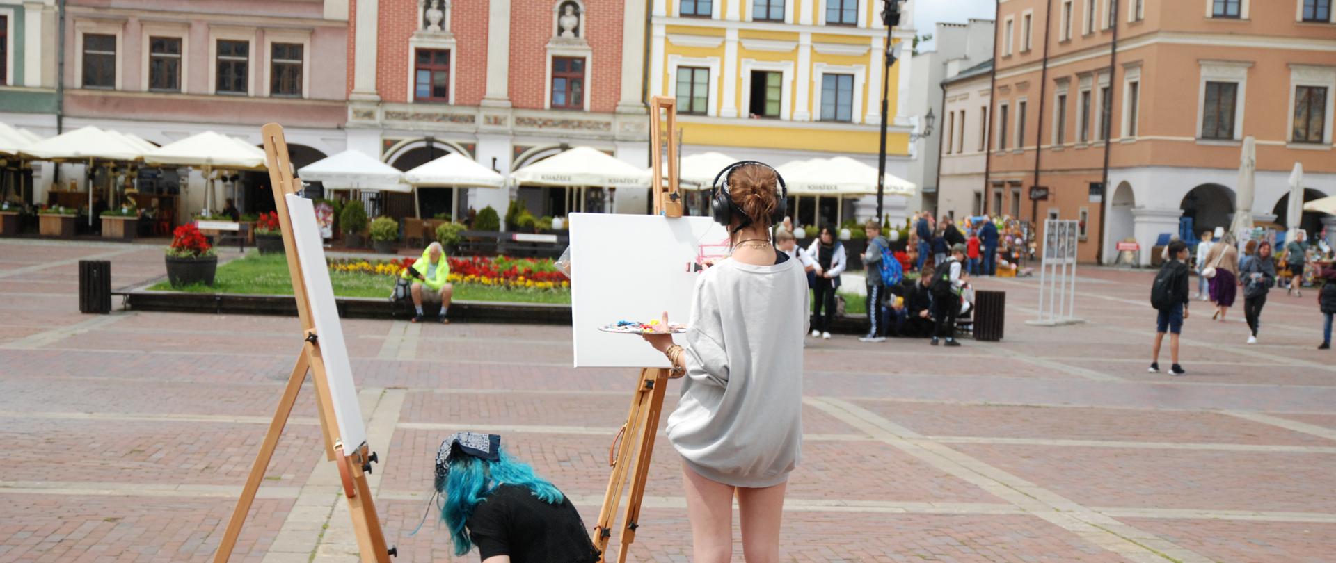 dwie dziewczynki malują obrazy, rynek starego miasta