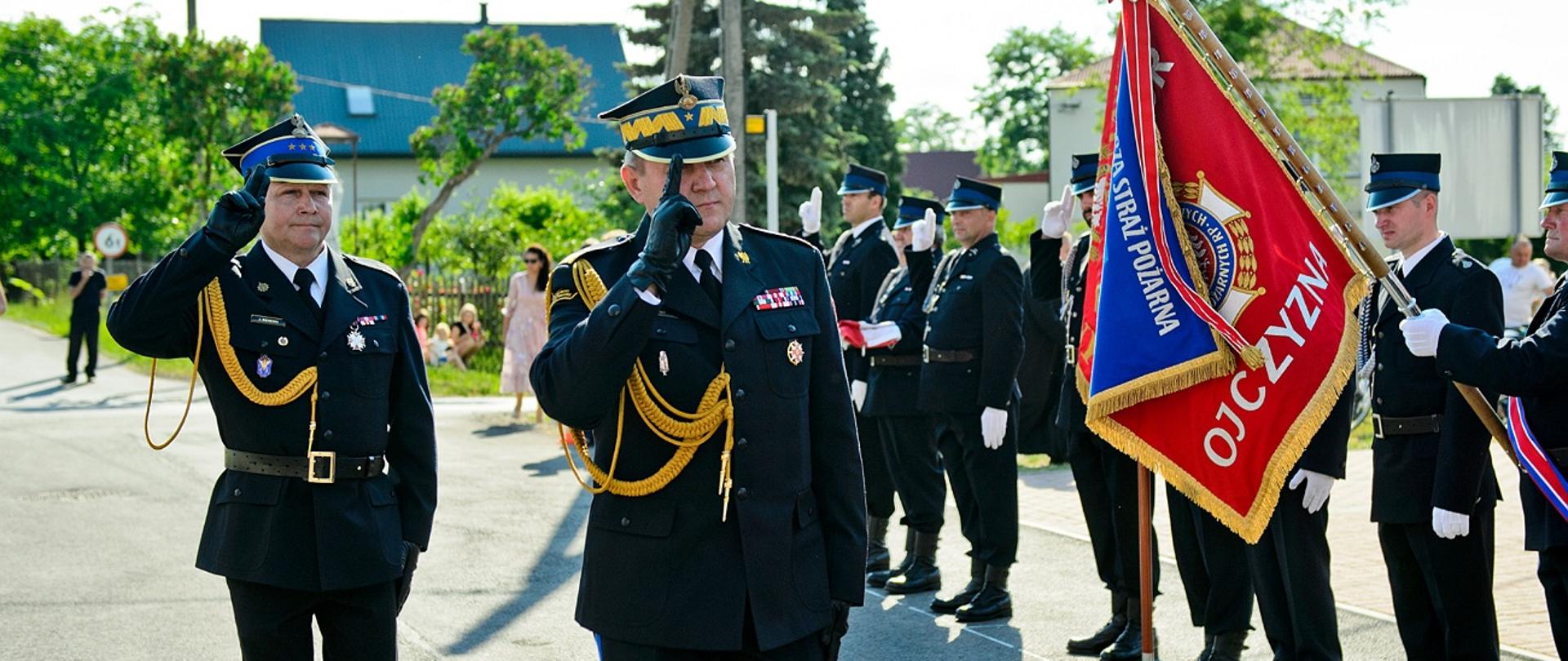 Generał wraz z asystującym oficerem maszerują przed pododdziałami w trakcie przeglądu pododdziałów.
