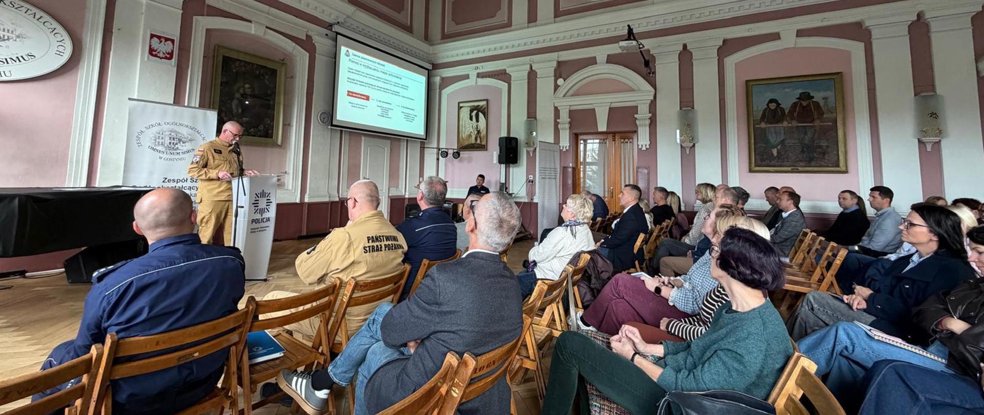 Funkcjonariusz KP PSP Gostyń przemawia przed zebranymi osobami.