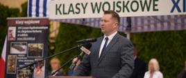 Minister Czarnek przemawia do mikrofonu, za nim napis Klasy wojskowe.