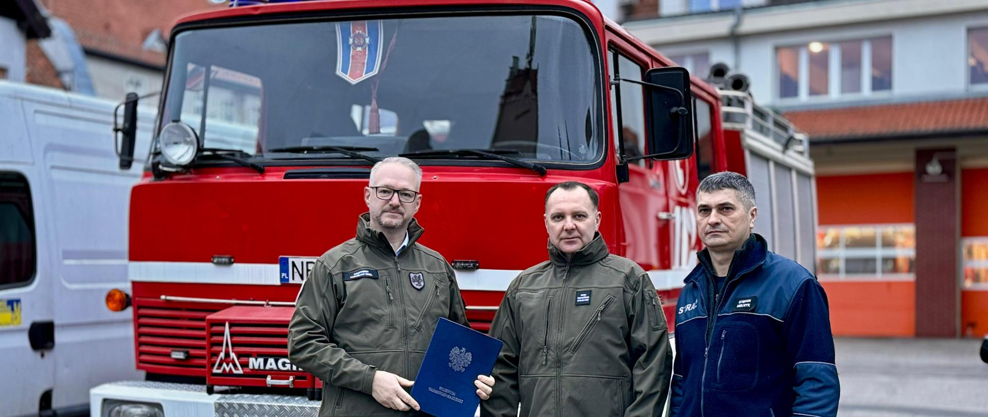 Symboliczne przekazanie sprzętu przez wojewodę Radosława Króla - na placu Komendy Wojewódzkiej Straży Pożarnej w Olsztynie - 8 grudnia 2024 r. - fot. nr 1.