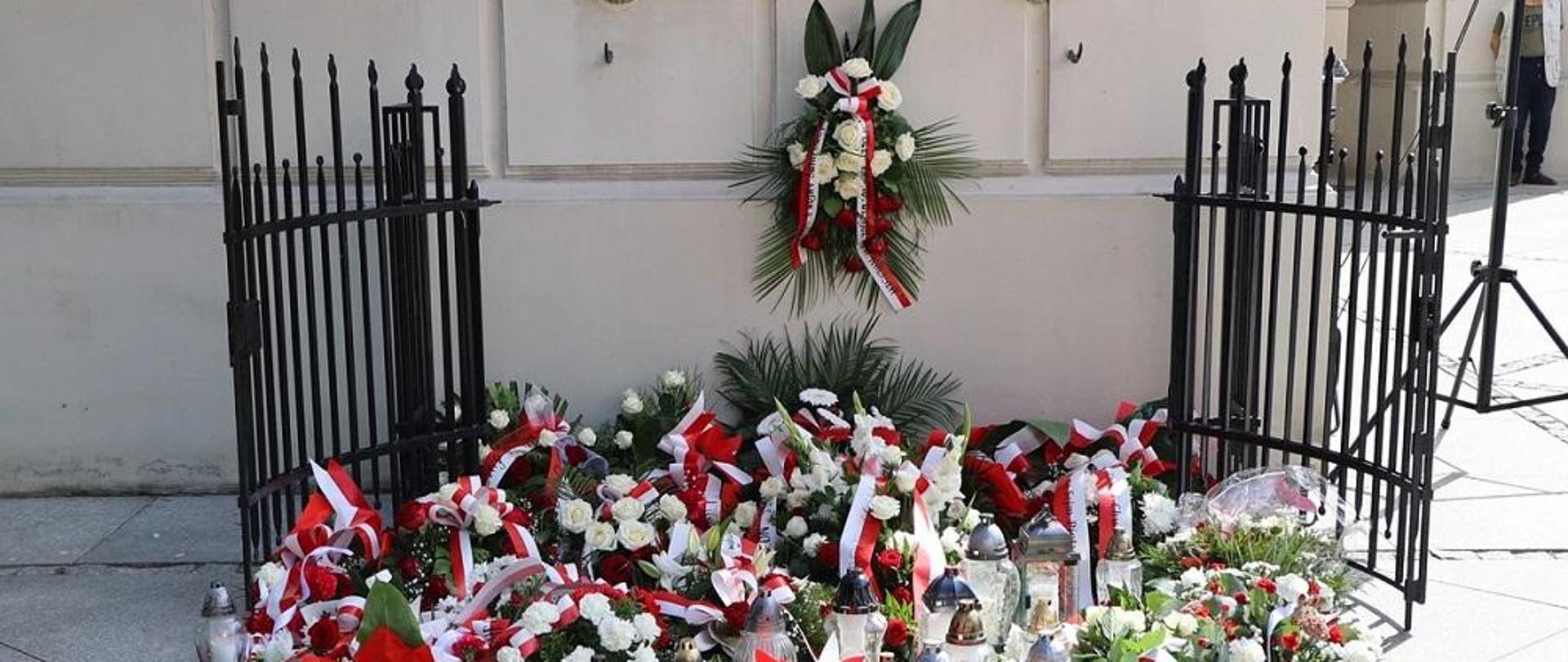 Wieńce złożone pod tablicą.