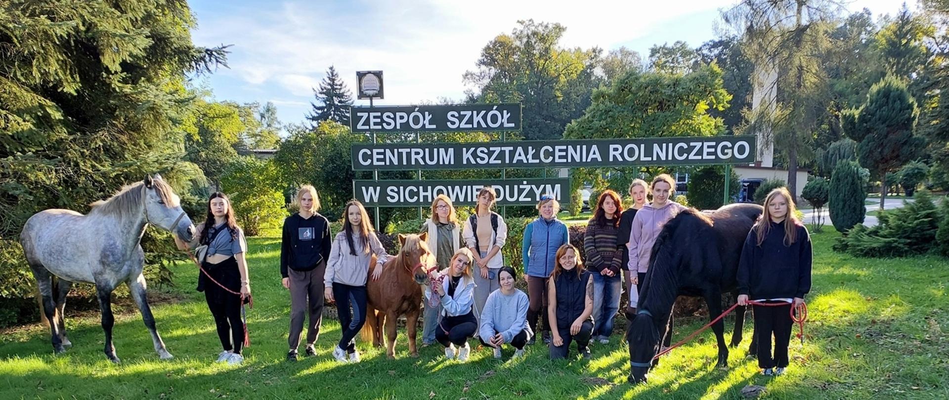 fotografia przedstawia zdjęcie członków koła jeździeckiego. Na zdjęciu znajdują się również konie.