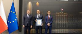 Trzech mężczyzn stoi na ściance Urząd Skarbowy Przyjazny Przedsiębiorcy