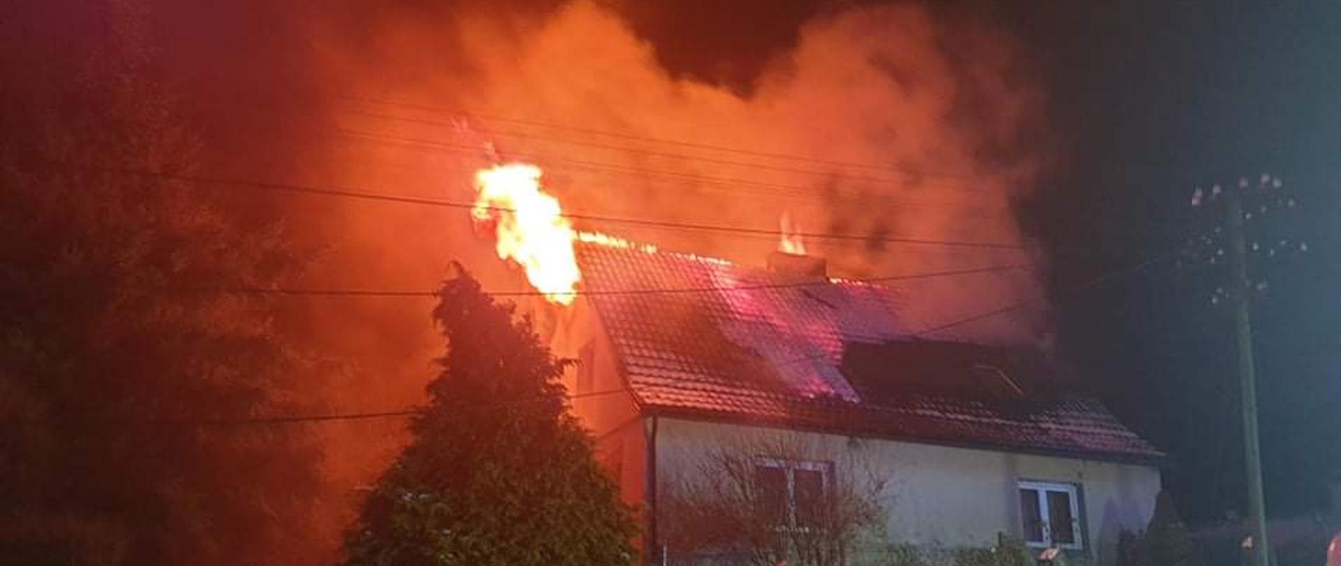 Na zdjęciu widać palący się dach budynku mieszkalnego ogień z lewej części dachu. 