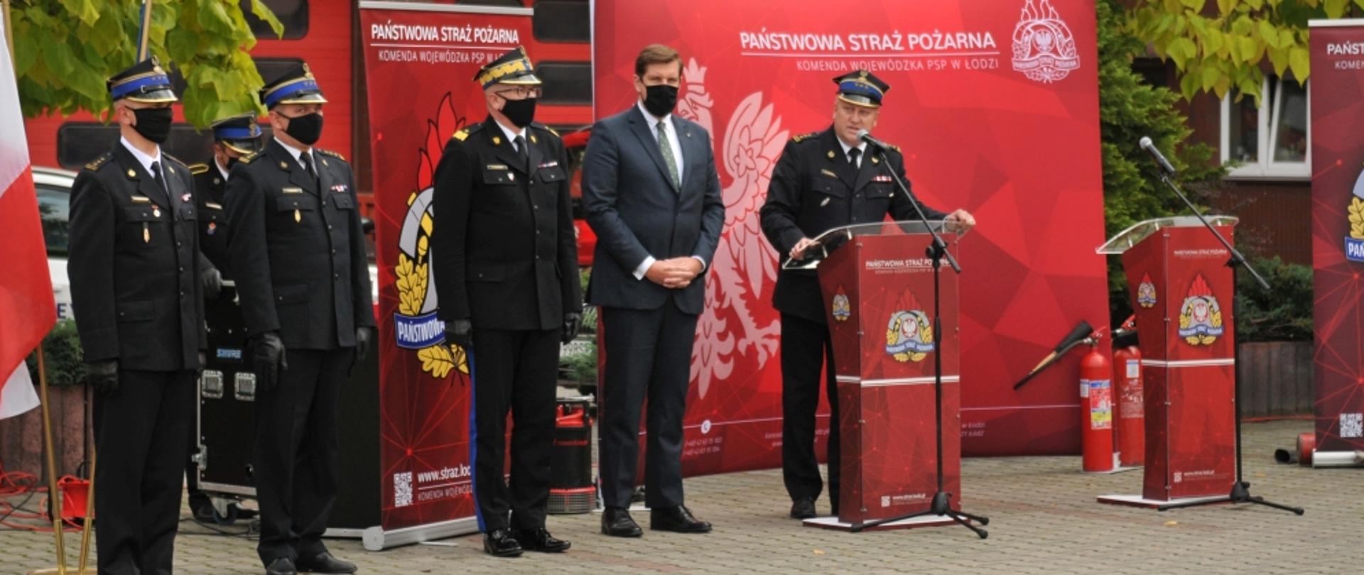 Zdjęcia przedstawia przemawiające komendanta wojewódzkiego PSP, Wojewodę Łódzkiego, zastępcę komendanta głównego PSP i zastępców łódzkiego komendanta wojewódzkiego PSP w Łodzi