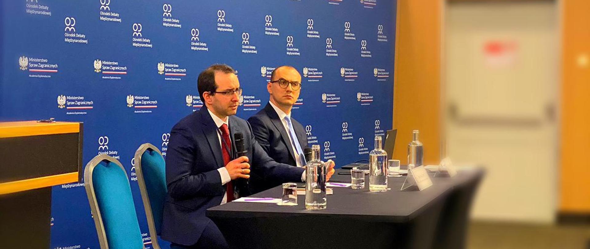 Minister Żaryn wygłasza wykład na tle prezentacji 