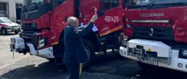 Ksiądz Dziekan podczas święcenia samochodów pożarniczych podczas uroczystości.