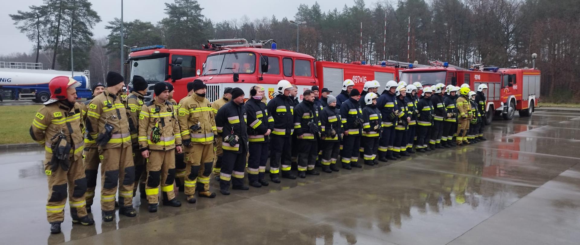 Zdjęcie przedstawia strażaków stojących na zbiórce przed ćwiczeniami.