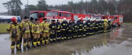 Zdjęcie przedstawia strażaków stojących na zbiórce przed ćwiczeniami.