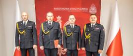 Wspólne zdjęcie nadbryg. Krzysztof Kędryk Opolski Komendant Wojewódzki PSP, st. bryg. Dariusz Gieroń Zastępca Opolskiego Komendanta Wojewódzkiego PSP, st. kpt. Roman Wyszka oraz st. kpt. Marcin Mazur.
Strażacy na tle Flag RP oraz planszy czerwonej z białym napisem Państwowa Straż Pożarna Komenda Wojewódzka PSP w Opolu i Godłem RP.
Strażacy w umundurowaniu galowym.