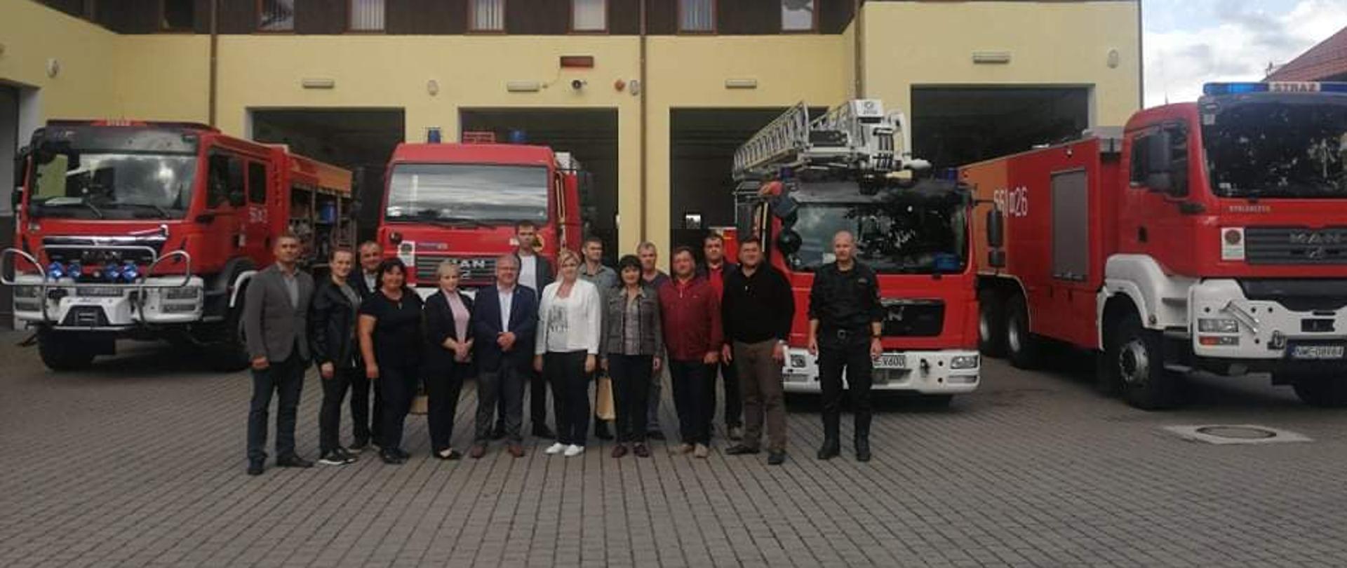 Na placu komendy przed garażami stoją przedstawiciele Mołdawii wraz władzami samorządowymi i komendantem. Na ich tle stoją samochody gaśnicze. 