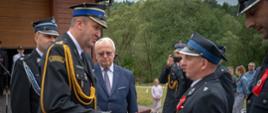 Na zdjęciu widoczni strażacy OSP w ubraniach galowych koloru granatowego przyjmujący z rąk Zastępcy Małopolskiego Komendanta Wojewódzkiego akt przekazania samochodu pożarniczego podczas uroczystego apelu z okazji przekazania samochodu ratowniczo-gaśniczego dla OSP Smerekowiec