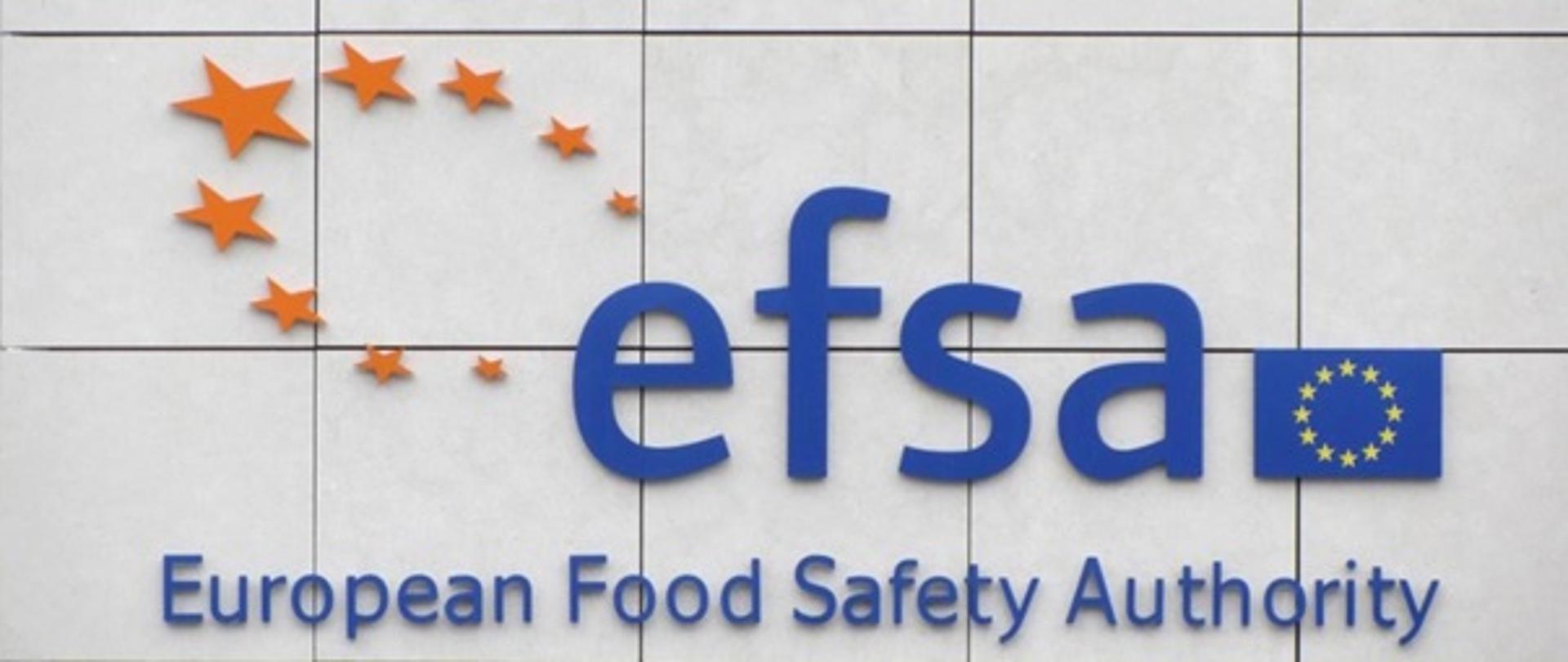 Napis efsa European Food Safety Authority, flaga Unii Europejskiej oraz żółte gwiazdy róznej wielkości ułożone w kształt koła
