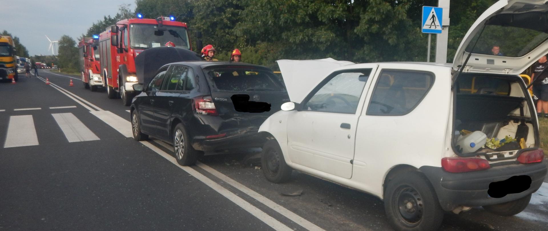 Zdjęcie przedstawia dwa samochody osobowe, które brały udział w zdarzeniu - białego fiata i czarną skodę.