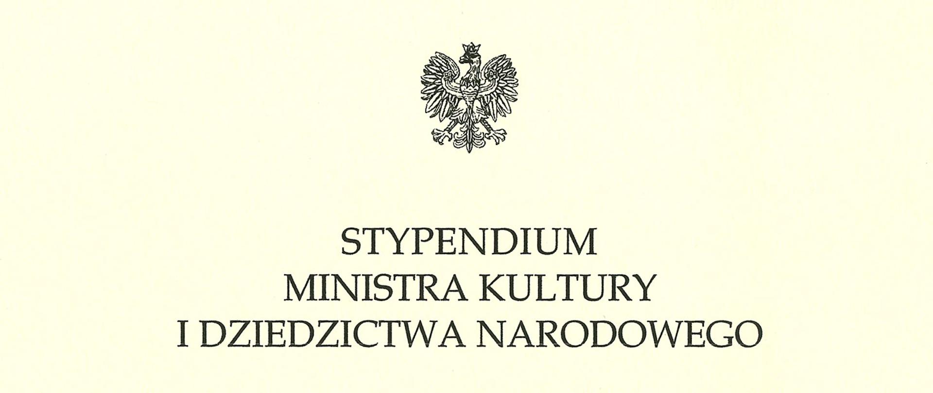 Oficjalny nagłówek dokumentu. Jest to pozioma, kremowa grafika przedstawiająca czarny tekst napisany elegancką, drukowaną czcionką. Na samej górze, na środku, znajduje się godło Polski – orzeł w koronie. Poniżej widnieje trzywersowy napis w języku polskim: „STYPENDIUM MINISTRA KULTURY I DZIEDZICTWA NARODOWEGO”.