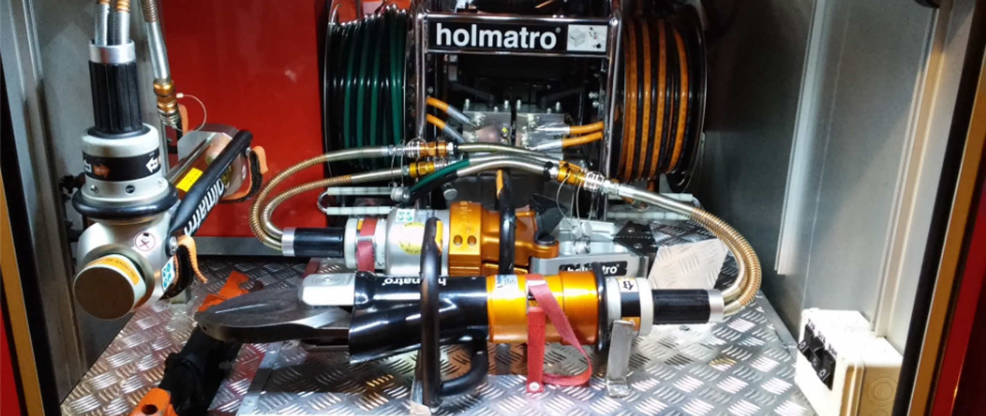 Fotografia przedstawiająca zestaw narzędzi hydraulicznych holmatro służących do rozcinania pojazdów podczas zdarzeń z samochodami.