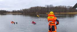 Na zdjęciu widzimy strażaka rzucającego z pomostu rzutkę ratowniczą.