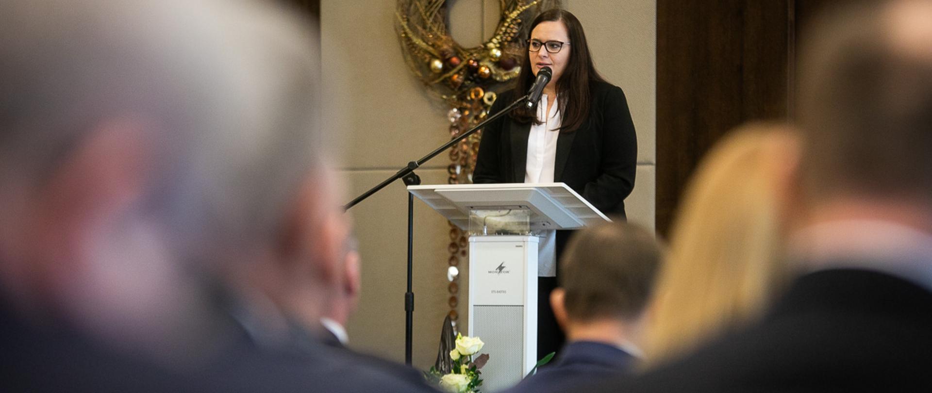 przy pulpicie stoi i mówi do mikrofonu minister Małgorzata Jarosińska-Jedynak