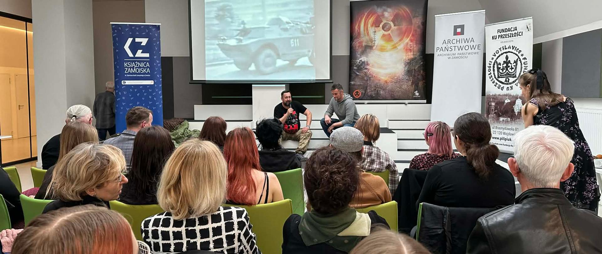 zdjęcie grupowe, publiczność słucha prelekcji , wyświetlane slajdy