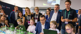 Premier Mateusz Morawiecki na govtech w otoczeniu dzieci przed makietą miasta