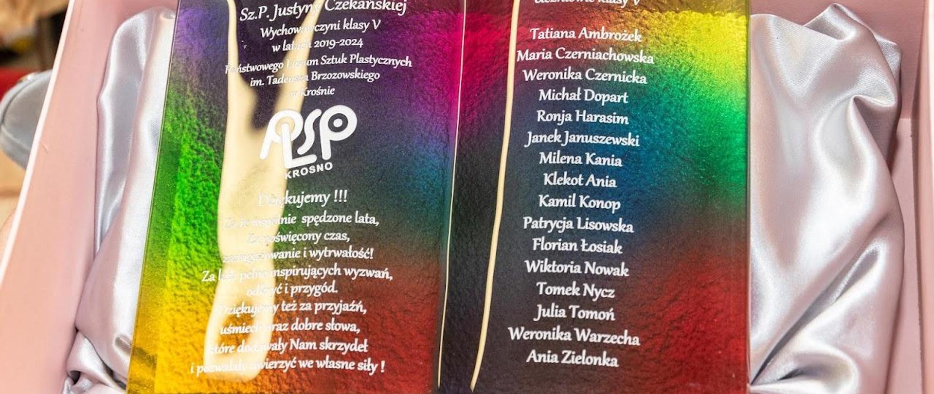 Podziękowania absolwentów dla wychowawcy. Rzeźba szklana, przypominająca otwartą księgę.