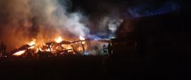 Strażacy PSP i OSP gaszący palące się zabudowania