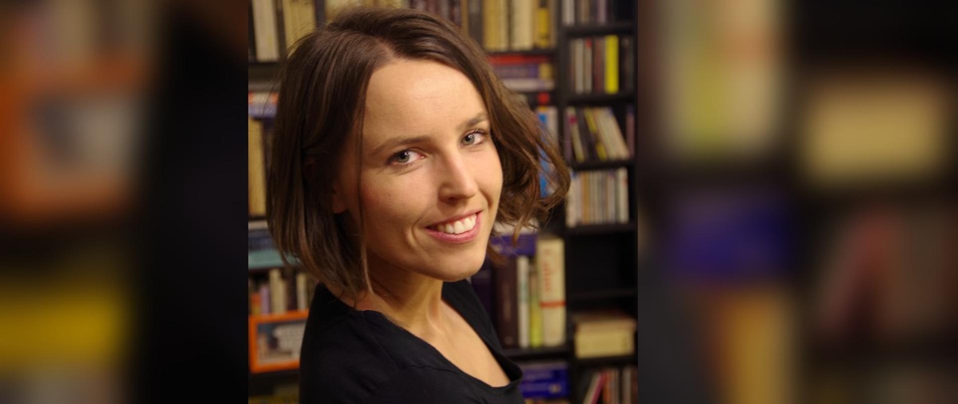 Ładnie ubrana kobieta na tle biblioteczki