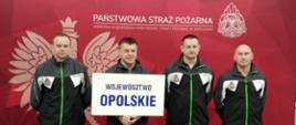Reprezentacja Państwowej Straży Pożarnej województwa opolskiego. Strażacy w strojach sportowych stoją na tle banneru Państwowej Straży Pożarnej koloru czerwonego trzymając tablicę białą z napisem: województwo opolskiego.