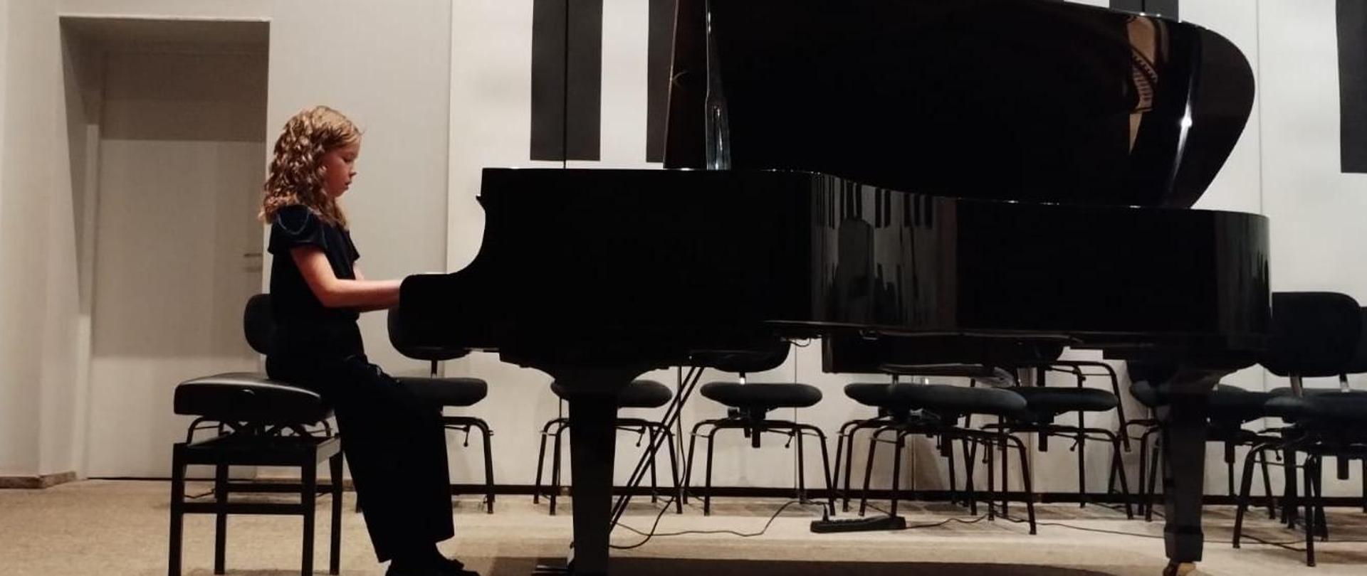 Dziewczynka gra na fortepianie w auli PSM 