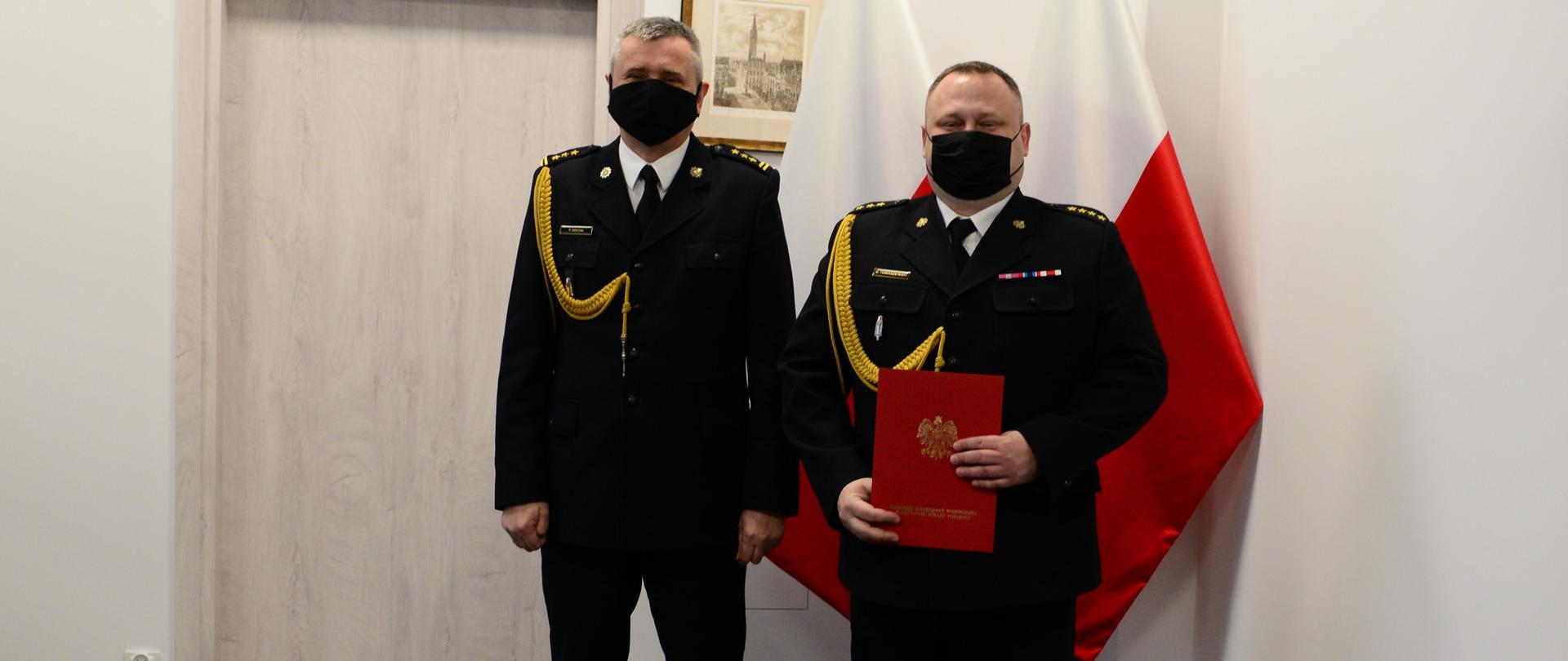 Pomorski komendant wojewódzki Państwowej Straży Pożarnej wręcza funkcjonariuszowi akt powierzenia obowiązków komendanta powiatowego Państwowej Straży Pożarnej w Malborku. 