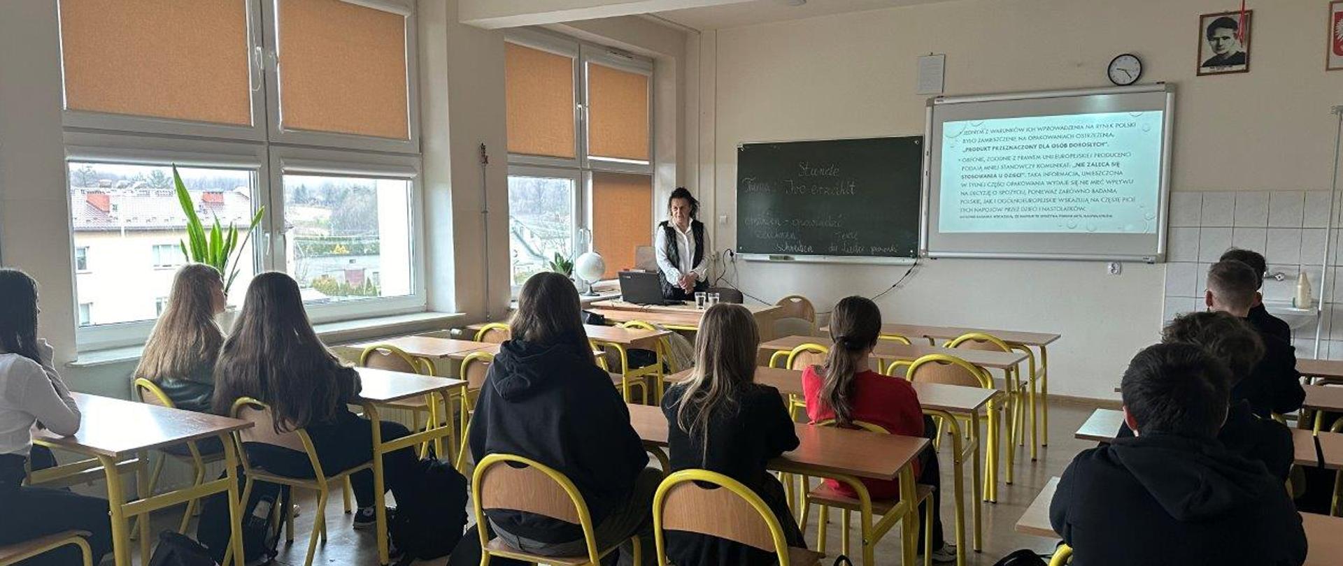 Przedstawicielka Oddziału Promocji Zdrowia i Oświaty Zdrowotnej WSSE w Kielcach – Agnieszka Dolezińska przedstawia temat dot. zagrożeń związanych ze spożywaniem napojów energetycznych dla uczniów Szkoły Podstawowej w Masłowie