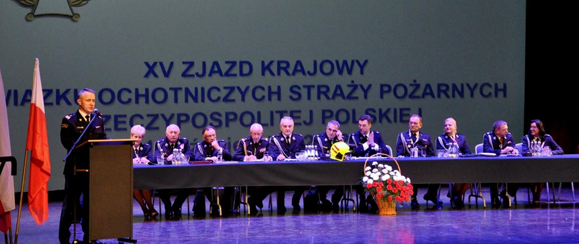 Na zdjęciu widać komendanta głównego PSP podczas przemówienia oraz prezydium ZOSP RP na scenie 