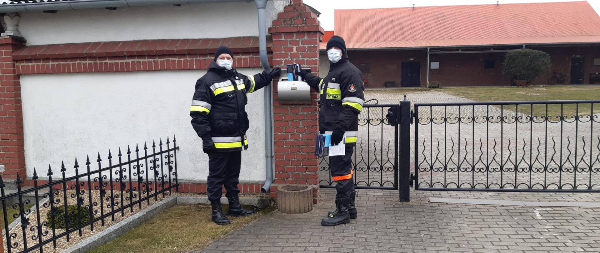 Funkcjonariusze OSP w umundurowaniu koszarowym podczas akcji dystrybucji ulotek.