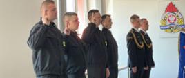 Strażacy składają ślubowanie. 4 strażaków wykonuje gest ślubowania. 