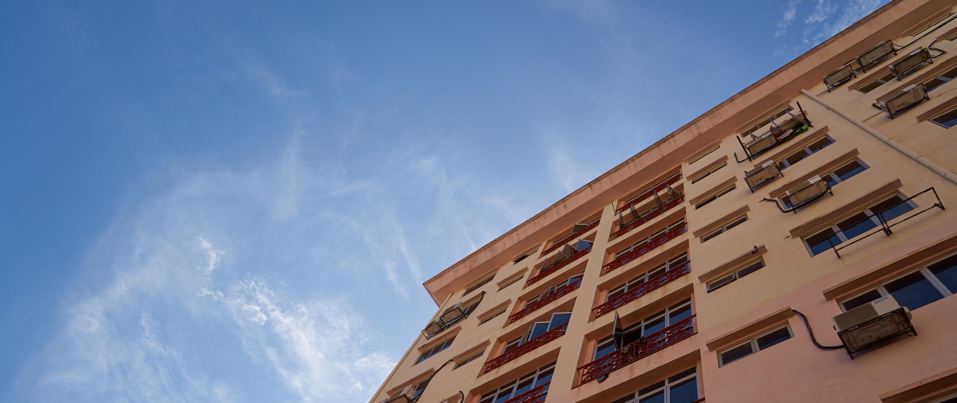 Na zdjęciu blok mieszkalny na tle nieba