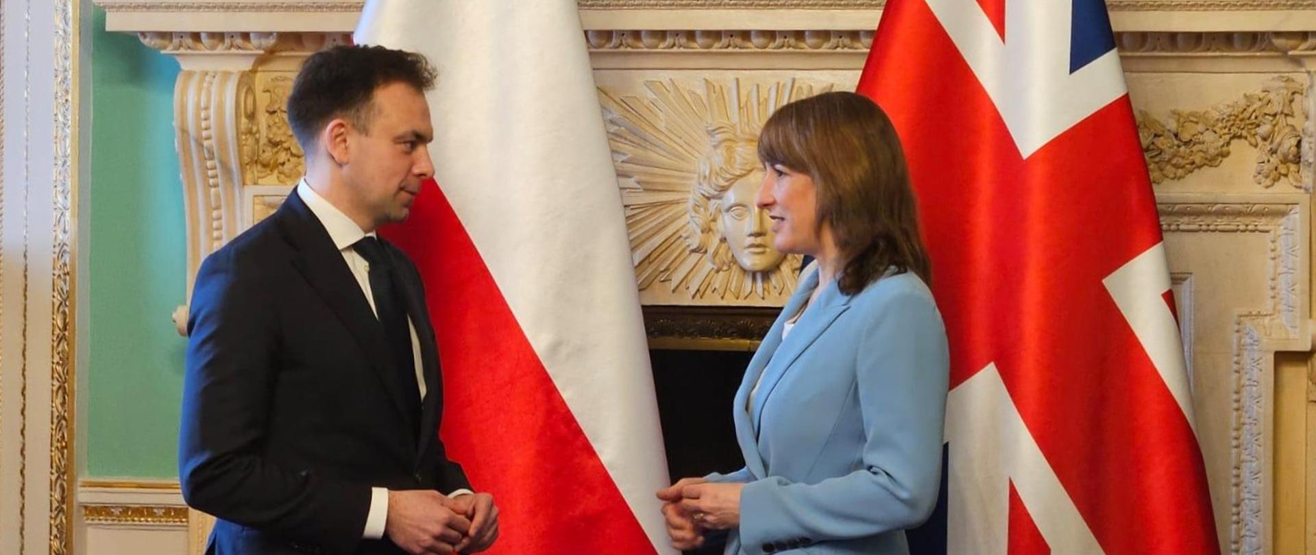 Rozmowa ministra Domańskiego z Kanclerz Skarbu Rachel Reeves (na tle flag)