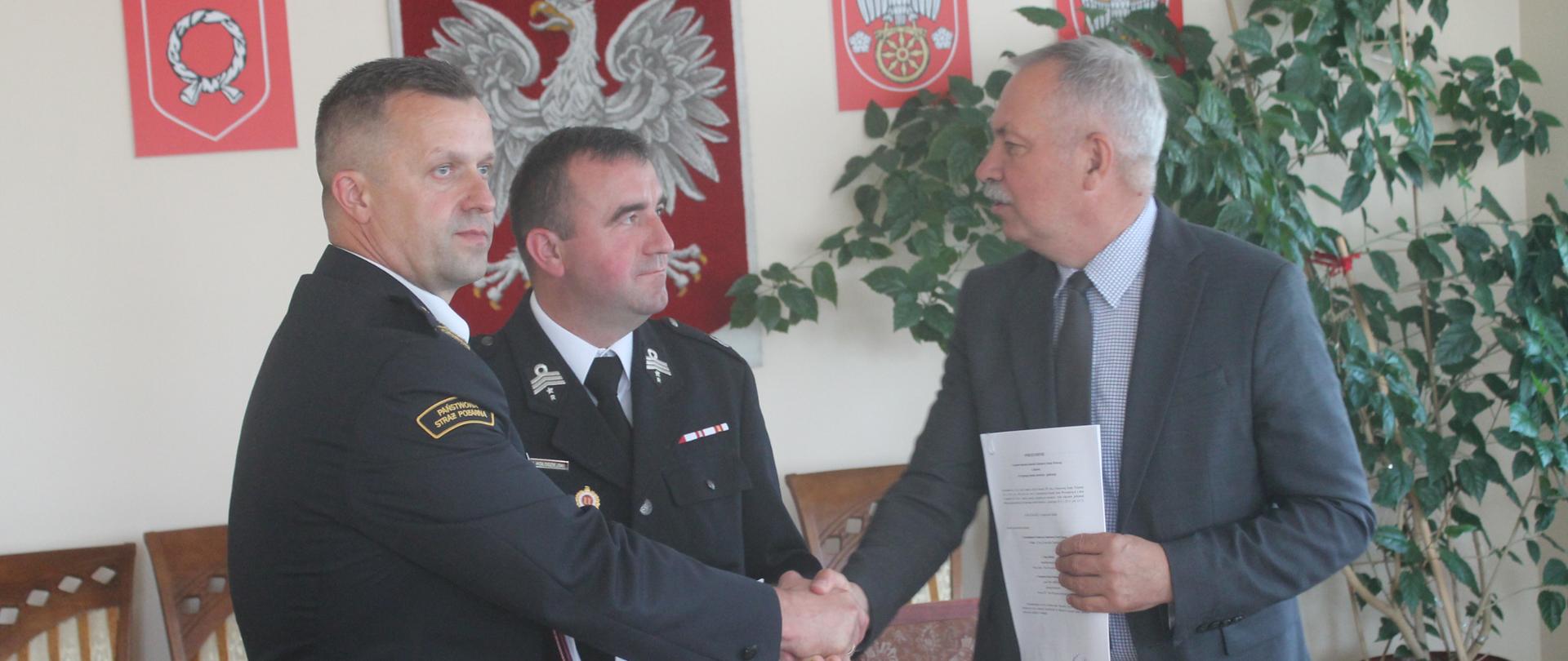 Wspólne zdjęcie Prezesa OSP, Wójta Gminy oraz Komendanta PSP po podpisaniu porozumienia.