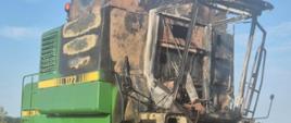  Na zdjęciu znajduje się spalony kombajn John Deere stojący na polu 