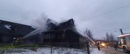 Dogaszanie palącego się budynku w miejscowości Czerwienne.