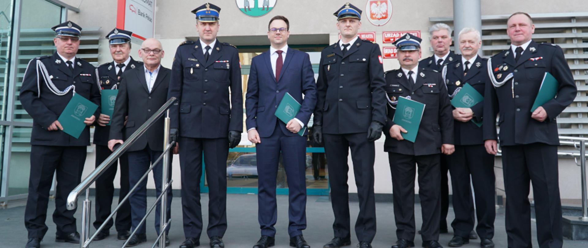 Zdjęcie przedstawia Komendantów Miejskich PSP w Jaworznie, Zastępcę Prezydenta Miasta Jaworzna Łukasza Kolarczyka oraz prezesów jaworznickich OSP na tle Urzędu Miejskiego w Jaworznie.