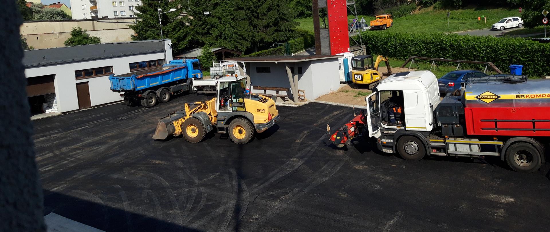 Wylany asfalt a na nim maszyny budowlane