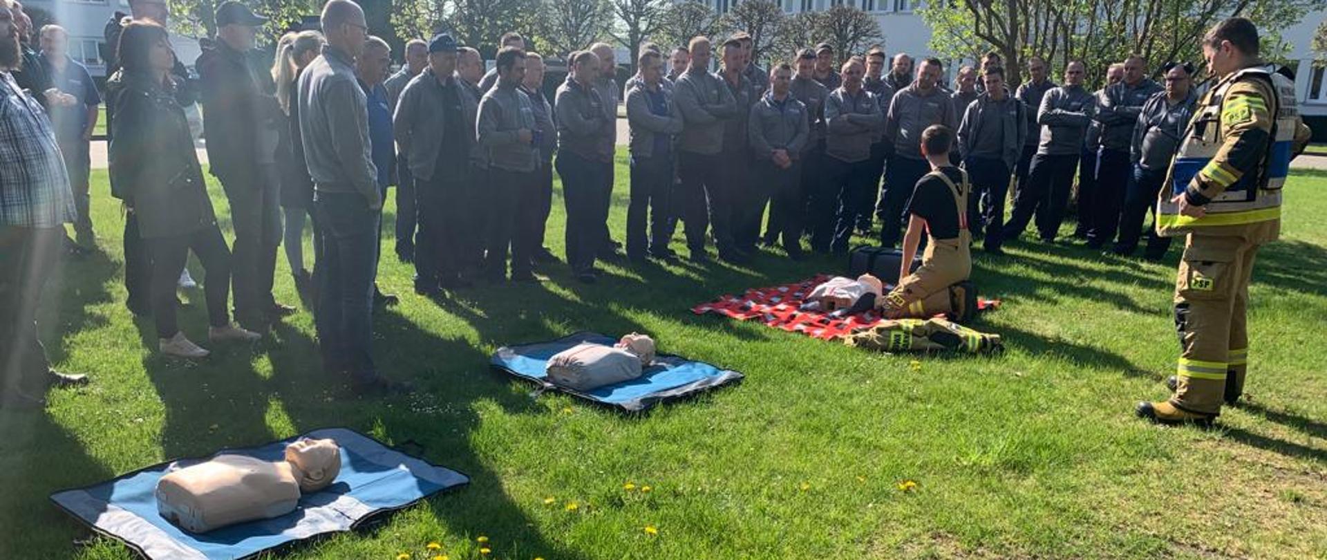 Grupa pracowników Aesculap Chifa podczas instruktarzu z kwalifikowanej pierwszej pomocy.